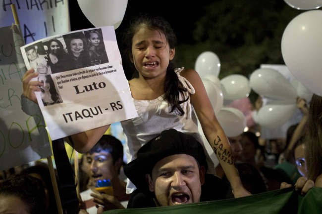 A girl cries during a march in a plaza near the Kiss nightclub honoring the victims of early Sunday’s fatal fire inside the club in Santa Maria, Brazil, Monday. (AP-Yonhap News)