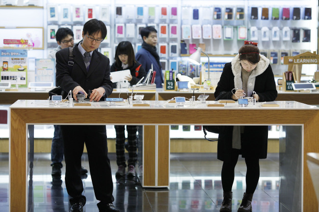 Customers try Samsung Electronics Co. Galaxy Note II smartphones at the Samsung d’light store in Seoul. (Bloomberg)