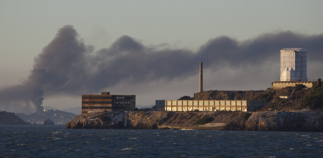 In this Aug. 6, 2012 file photo, smoke pours from a fire at the Chevron Richmond Refinery, seen behind Alcatraz Island in San Francisco. ( AP-Yonhap News)