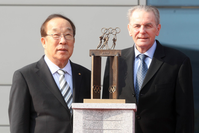 IOC president Jacques Rogge (right) and Korean Olympic Committee president Park Yong-sung pose behind a miniature version of “The Large Door,” which Rogge donated at the Jincheon Training Center in North Chungcheong Province on Thursday. The original “Door” is on display at the IOC headquarters in Lausanne, Switzerland. (Yonhap News)