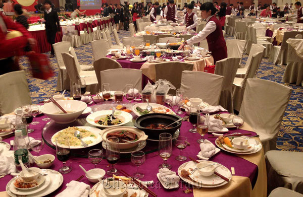 Waitresses clear tables, after a dinner for staff members from a state-owned enterprise at a five-star hotel in Guangzhou, Guangdong province, China. (Xinhua News Agency)