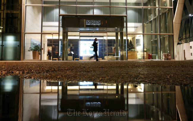 A pedestrian passes the entrance to the regional offices of the Royal Bank of Scotland Group Plc in Manchester, England. (Bloomberg)