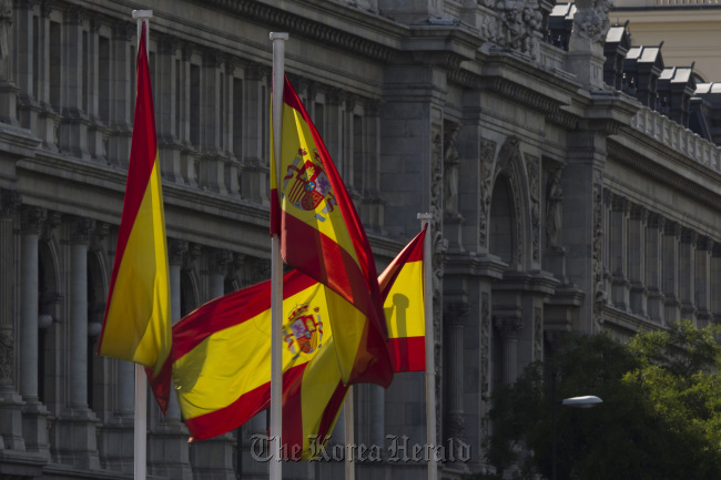 Spanish national flags fly outside the Bank of Spain headquarters in Madrid. (Bloomberg)