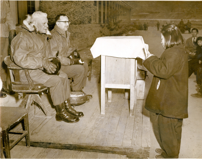 This undated photo released by the Ministry of Patriots and Veterans Affairs shows Gen. Joseph Cleland (left), commander of then U.S. Army 40th Infantry Division, attending a graduation ceremony at Kaiser Middle and High School, now Gapyong High School, during the Korean War. (Yonhap News)