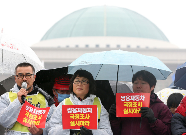 A group of labor activists holds a news conference in front of the presidential transition committee building in central Seoul to call for reinstatement of the dismissed Ssangyong Motor last week. (Yonhap News)