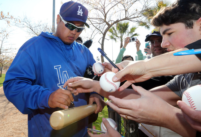 Dodgers pitcher Ryu Hyun-jin signs autographs during spring training in Glendale, Arizona, Tuesday. (Yonhap News)