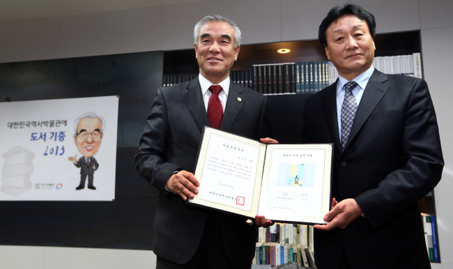 Culture Minister Choe Kwang-shik (left) receives a certificate of donation from Kim Wang-shik, director of the National Museum of Korean Contemporary History, on Wednesday after donating 2,013 books to the museum. (Yonhap News)