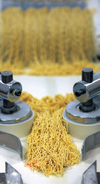 Freshly-cut ramen noodles move along a conveyor at the Sun Noodle facility in Rancho Dominguez, California, on Jan. 22. (Los Angeles Times/MCT)