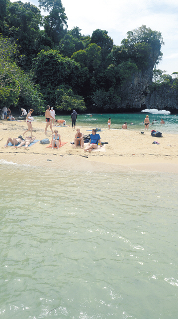 Tourists sunbathe on the powder white beach which slopes down to emerald green water in Koh Hong Island. (Chung Hee-cho/The Korea Herald)