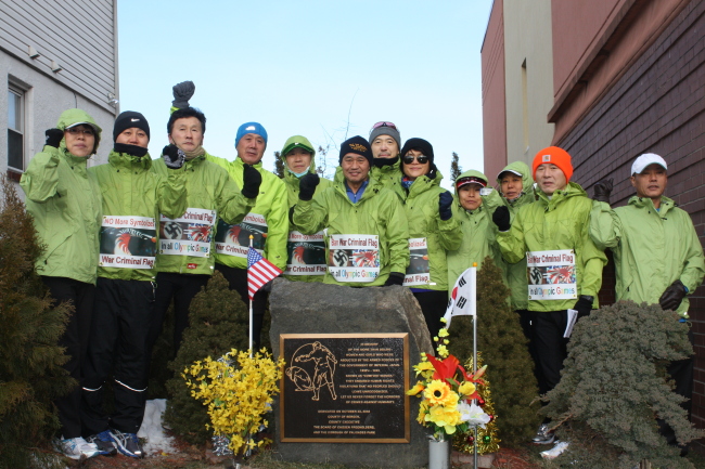 Runners pose around a memorial in memory of comfort women in New York, Sunday, before starting a marathon organized by the Citizens Against War Criminal Symbolism in hopes of banning the Rising Sun Flag, a symbol of Japanese militarism. (Yonhap News)