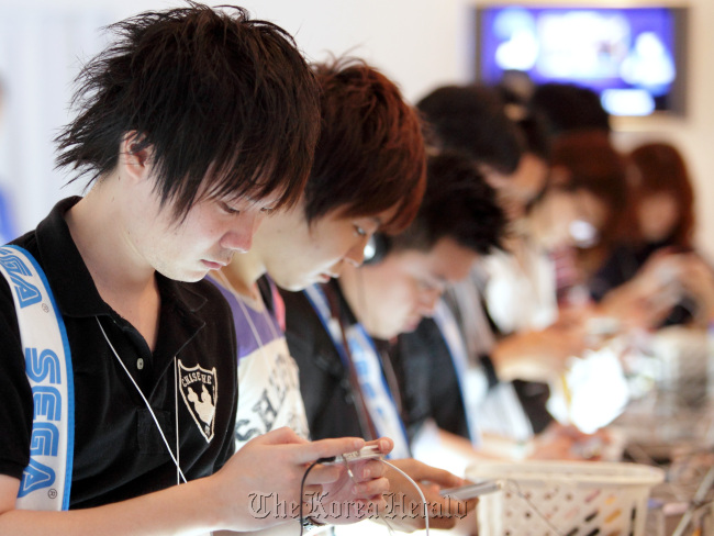 Visitors play game at the Tokyo Game Show 2012 at Makuhari Messe in Chiba, Japan. (Bloomberg)