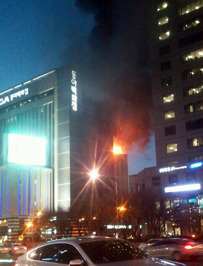 Smoke comes out from the eighth floor of Donga Department Store on Wednesday night. (Yonhap News)