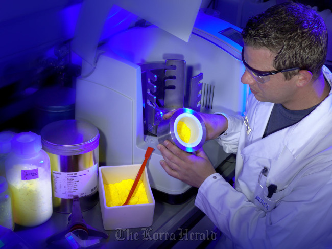 A researcher works on the development of lighting materials. (Merck Darmstadt)