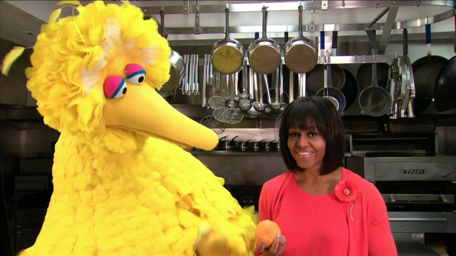 This undated handout video frame grab provided by the White House shows first lady Michelle Obama with Sesame Street’s Big Bird in the kitchen of the White House in Washington. (AP-Yonhap News)