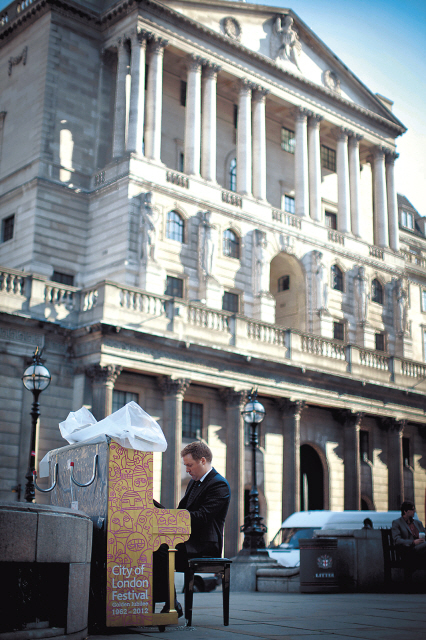 A businessman plays a “street” piano outside the Bank of England in London. (Bloomberg)