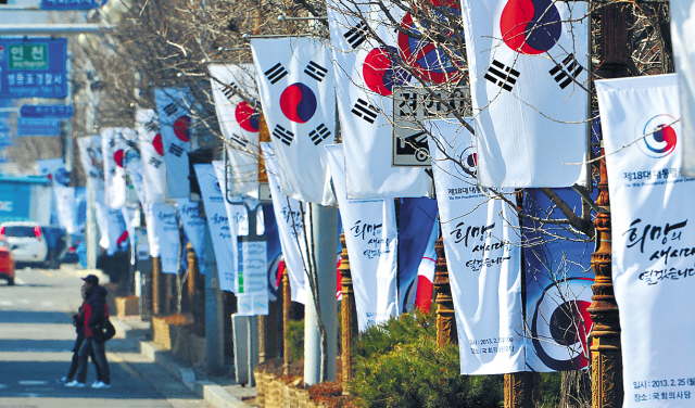 Taegeukgi, the national flag of South Korea, and commemorative flags adorn the trees in front of theNational Assembly, Yeouido, Seoul, where the presidential inauguration takes place Monday. (Yonhap News)