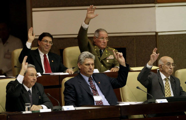 Cuba’s new Vice President Miguel Diaz-Canel (center, front row), Cuba’s President Raul Castro (left), Vice President Jose Ramon Machado Ventura (right) raise their hands to vote during the closing session at the National Assembly in Havana on Sunday. (AP-Yonhap News)