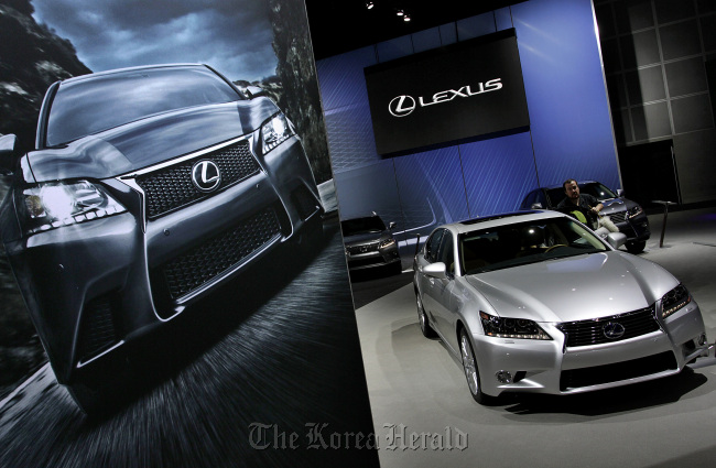 A worker cleans a Toyota Motor Corp. Lexus vehicle displayed at the company’s booth during the LA Auto Show in Los Angeles, California. (Bloomberg)