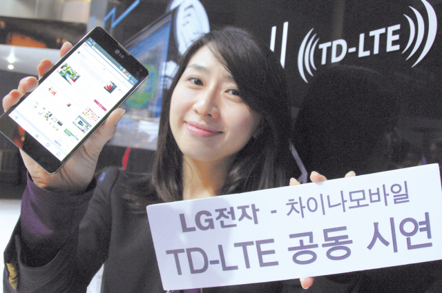 An LG employee holds up a sign announcing that LG Electronics jointly tested the TD-LTE service with China Mobile in Barcelona on Tuesday. (LGE)