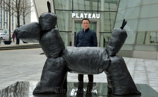 Artist Gim Hong-sok poses with his artwork on display at his solo exhibition at the Samsung Museum of Art Plateau. (Kim Myung-sub/The Korea Herald)