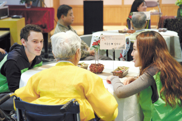 Volunteers participating in the Seoul Global Center’s program talk with a senior suffering from dementia. (Seoul Metropolitan Government)