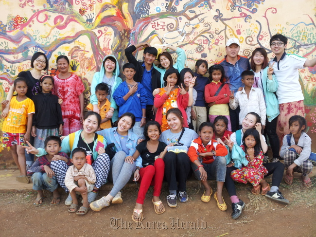 Students from Korea National University of Arts pose with children after painting school walls in Mondulkiri, Cambodia. (Korea National University of Arts)