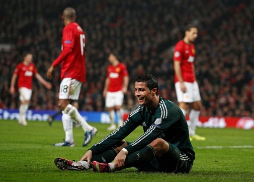 Real Madrid`s smiles as he sits on the pitch during their Champions League round of 16 soccer match at Old Trafford Stadium, Manchester, England, Tuesday, March 5, 2013. Real won the match 2-1 to beat Manchester United 3-2 on aggregate.