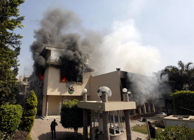 Smoke rises from the Egyptian soccer federation after protesters set it alight following a court verdict in Cairo on Saturday. ( AP-Yonhap News)