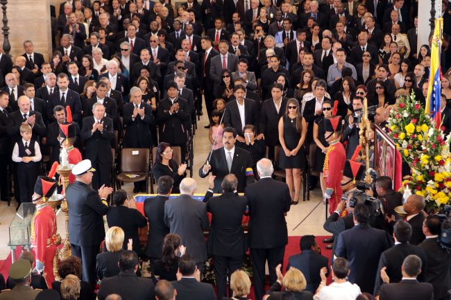 Venezuelan Vice President Nicolas Maduro (center) places a sword that belonged to South American liberator Simon Bolivar on the coffin of the late Venezuelan President Hugo Chavez in Caracas on Friday. (AFP-Yonhap News)