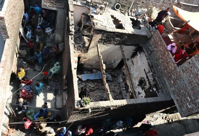 Pakistani Christians gather around their burned out homes torched by Muslim demonstrators in Lahore on Sunday. (AFP-Yonhap News)