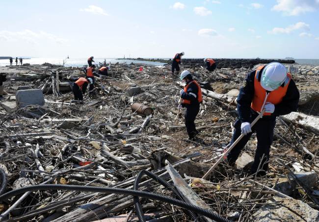 Police officers search for tsunami victims two years after, at the estuary of the Kyu Kitakami river in Ishinomaki, Miyagi prefecture on Monday. (AFP-Yonhap News)