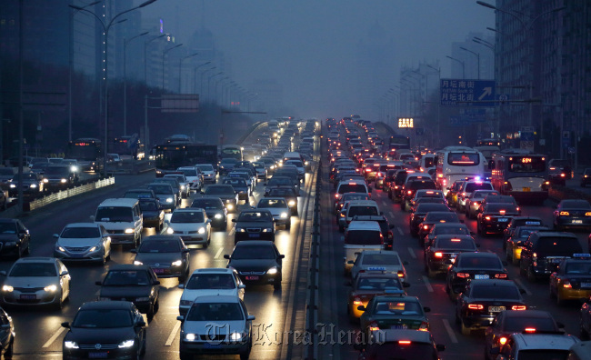 Traffic moves along a road at dusk in Beijing. (Bloomberg)