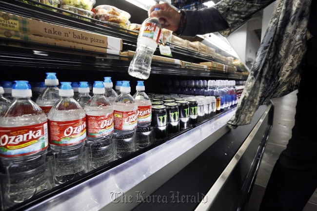 A customer takes a bottle of water off a store shelf in Jackson, Mississippi, Tuesday. (AP-Yonhap News)