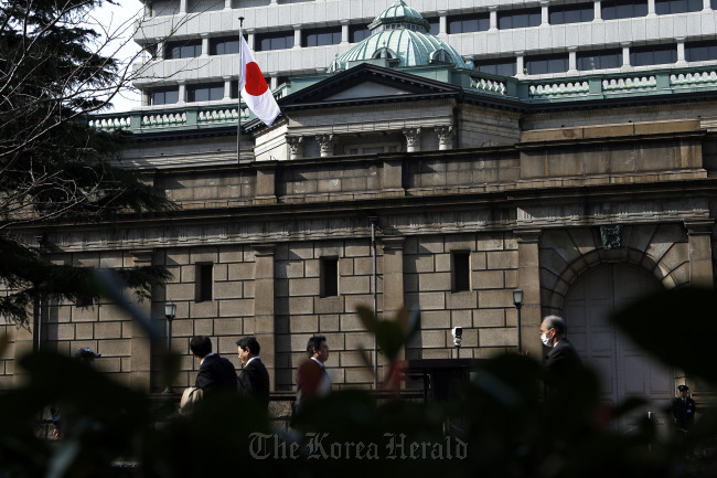 Pedestrians walk past the Bank of Japan headquarters in Tokyo. (Bloomberg)