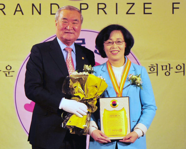 Park Chun-hee (right), mayor of Songpa district in Seoul, poses with Nam Jong-hyun, head of the Korea Association of Hanbit, after receiving the Korea Grand Prize for Sharing at 63City in Seoul on Wednesday. The association named her the prize winner. (Yonhap News)