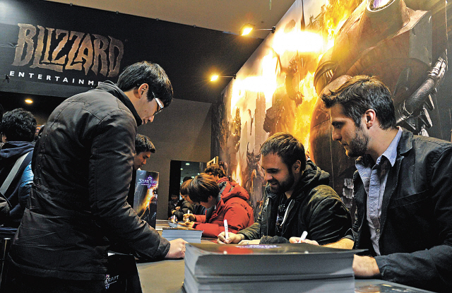 Game developers of “Starcraft 2: Heart of the Swarm” take part in a signing ceremony for the new expansion pack it released in Seoul on Monday. (Blizzard Entertainment)