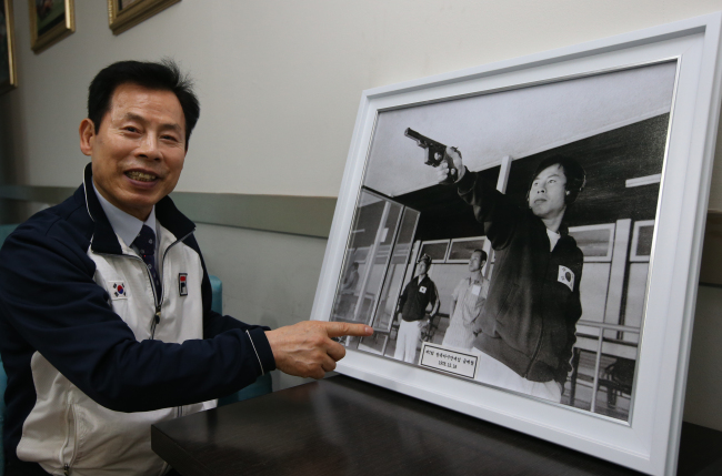 Taeneung Training Center director Park Jong-gil, who was named vice minister of culture, sports and tourism, points at a photo of him shooting in the 1978 Bangkok Asian Games at his indoor firing range in Mokdong, Seoul on Wednesday. (Yonhap News)