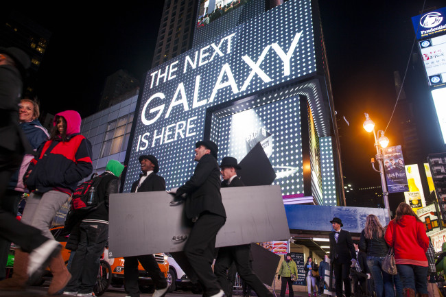 Samsung Electronics Co. signage is displayed on billboards as pedestrians walk by during the release of the Galaxy S4 smartphone in Times Square in New York on Thursday. (Yonhap News)