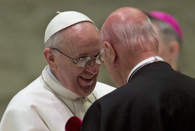 Pope Francis greets Archbishop Claudio Maria Celli during a meeting with the media at the Vatican on Saturday. (AP-Yonhap News)