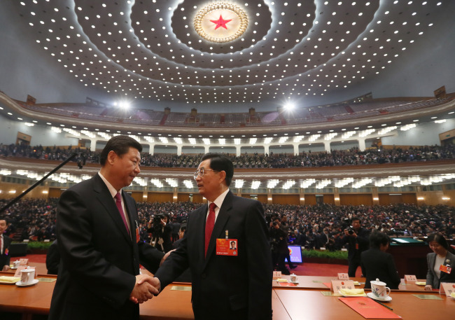 Xi Jinping (left) shakes hands with Hu Jintao at the closing meeting of the first session of the 12th National People’s Congress at the Great Hall of the People in Beijing on Sunday. ( Xinhua-Yonhap News)