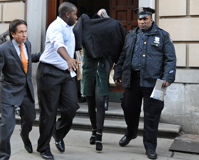 Lindsay Lohan, second from right, is escorted from the 10th Precinct police station, with her face shielded, Thursday. (AP-Yonhap News)