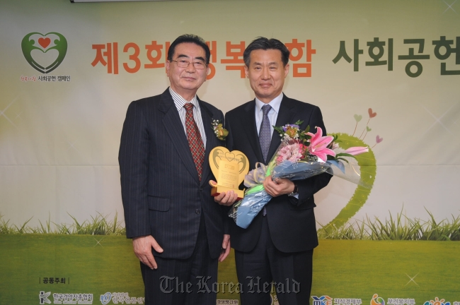 BNP Paribas Cardif Life Insurance deputy chief executive Park Yong-kyun (right) and Journalists Organization of Korea chairman Sung Dae-seok pose at the 2013 Adding Happiness Social Contribution Awarding Ceremony in Seoul last week. (BNP Paribas Cardif Life)