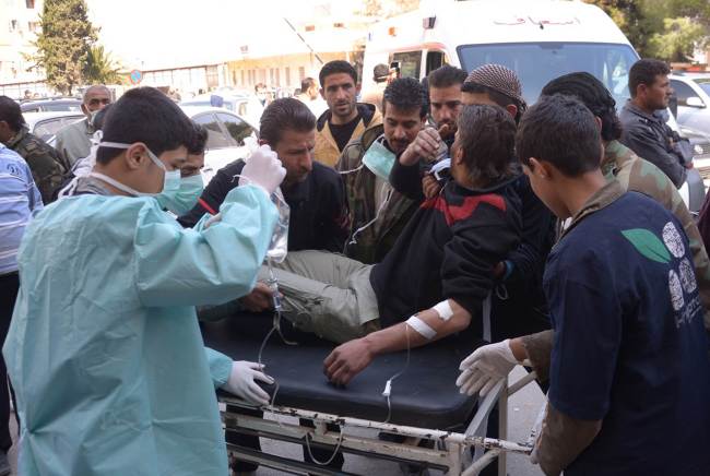 A man is brought to a hospital in the Khan al-Assal region in the northern Aleppo province, Syria, Tuesday, as Syria’s government accused rebel forces of using chemical weapons for the first time. (AFP-Yonhap News)