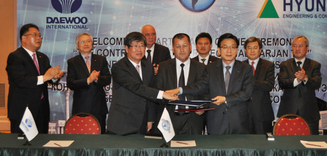 Daewoo International Corp. vice chairman Lee Dong-hee (from left, front row), Uzbekenergo director Basidov and Hyundai Engineering & Construction president Jung Soo-hyun shake hands after signing a deal to build a power plant at a ceremony in Tashkent on Tuesday. (Hyundai E&C)