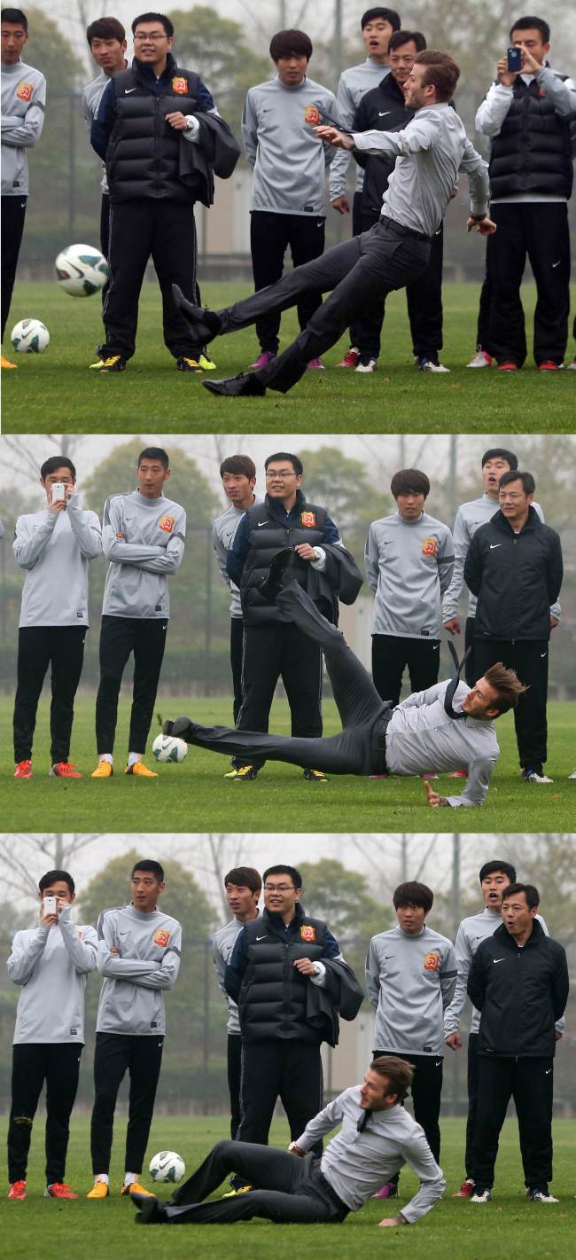 OOPS: Soccer star David Beckham slips while showing how to take a free kick during a visit to Zall soccer club in Wuhan, China, Saturday. (AFP-Yonhap News)