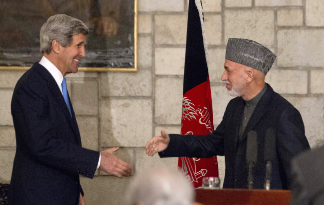 U.S. Secretary of State John Kerry reaches to shakes hands with Afghan President Hamid Karzai at the end of their joint news conference at the presidential palace in Kabul on Monday. (AP-Yonhap News)