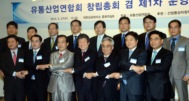 Former CEO of Homeplus Lee Seung-han (third from left, front row) joins hands with founding members of the council of retailers at a ceremony in Seoul on Wednesday. Lee was elected as co-chair of the new group. (Chung Hee-cho/The Korea Herald)