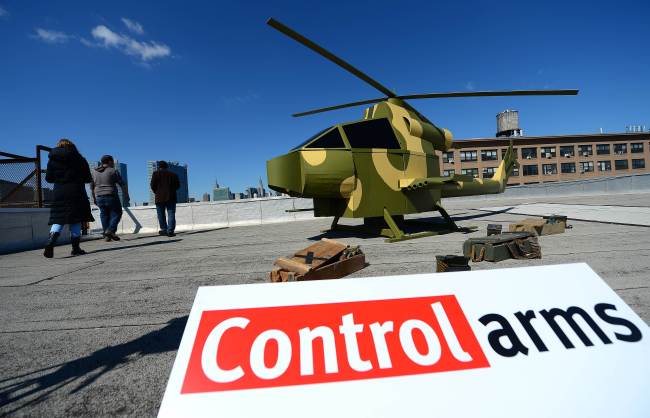 A replica of a camouflage military-style helicopter stands on a rooftop across Manhattan’s skyline and the United Nations headquarters during a campaign by Control Arms Coalition activists in New York on Wednesday. (AFP-Yonhap News)