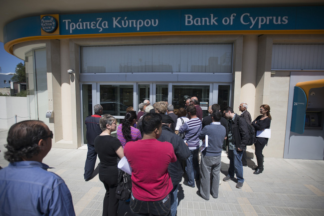 Customers queue outside a Bank of Cyprus Plc branch ahead of opening in Nicosia, Cyprus, Thursday. (Bloomberg)