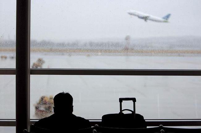 A traveler watches an airplane taking off. (Bloomberg)